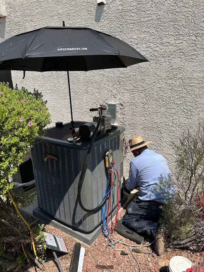 HVAC technician performing outdoor AC maintenance in South Hadley